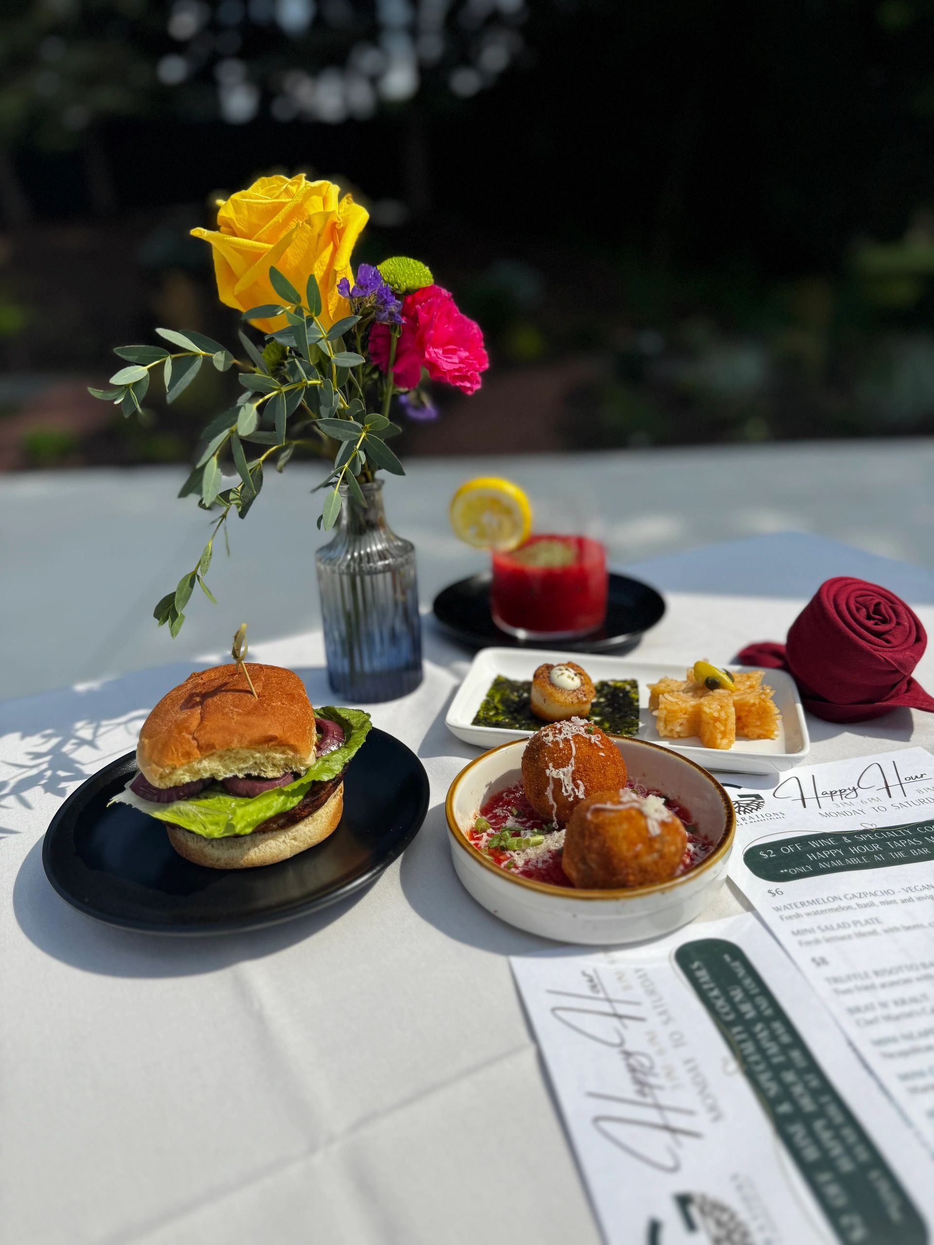 A wooden table set with two dishes and rose-shaped red napkins.